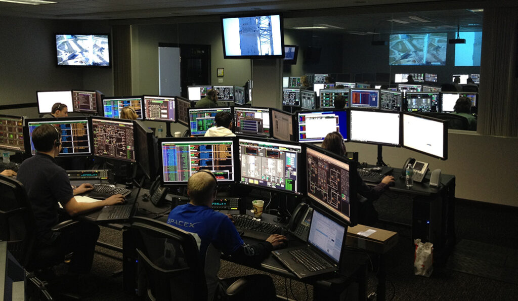 People on computers in control room